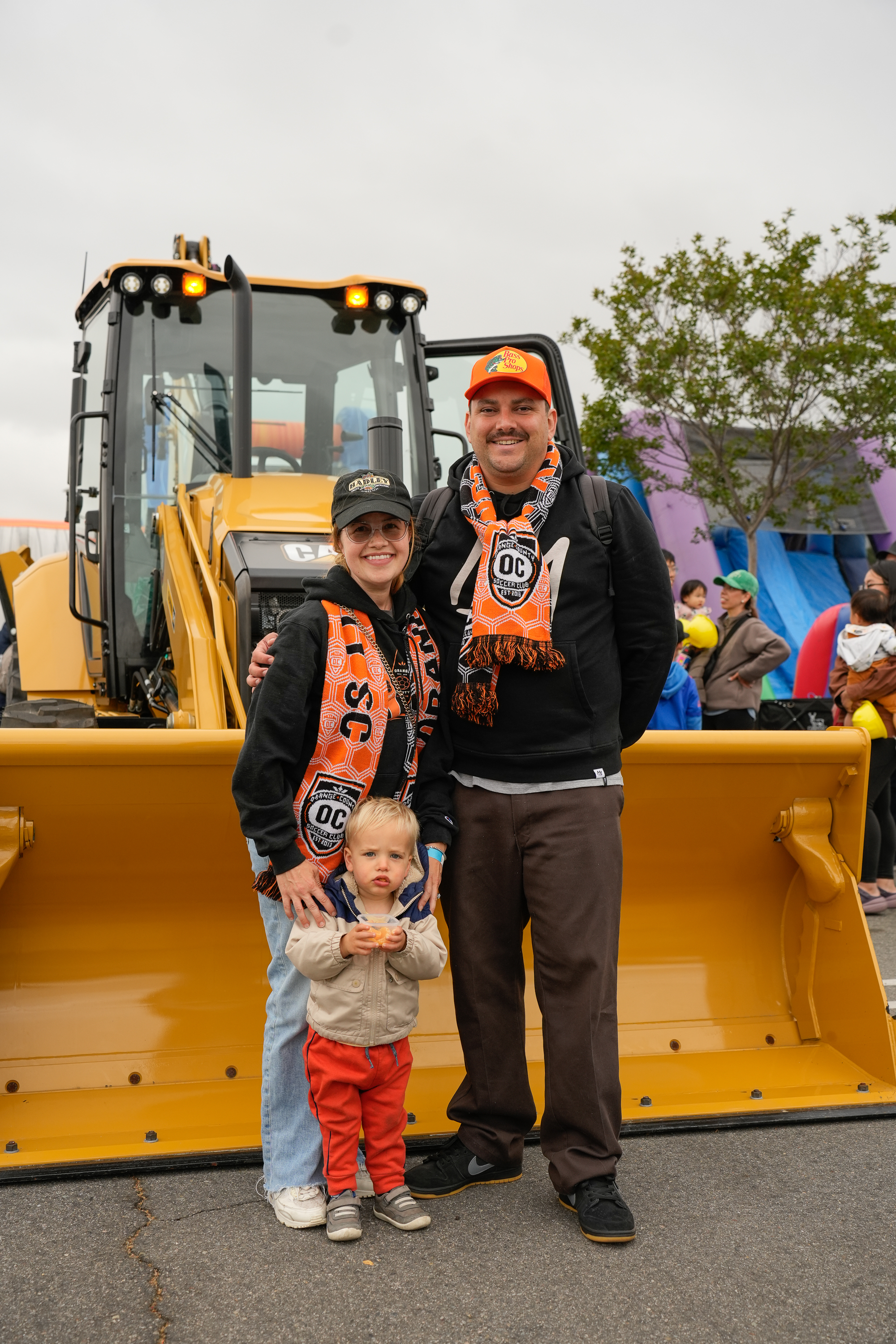 An Orange County SC family posing together in front of a construction vehicle at Touch-A-Truck